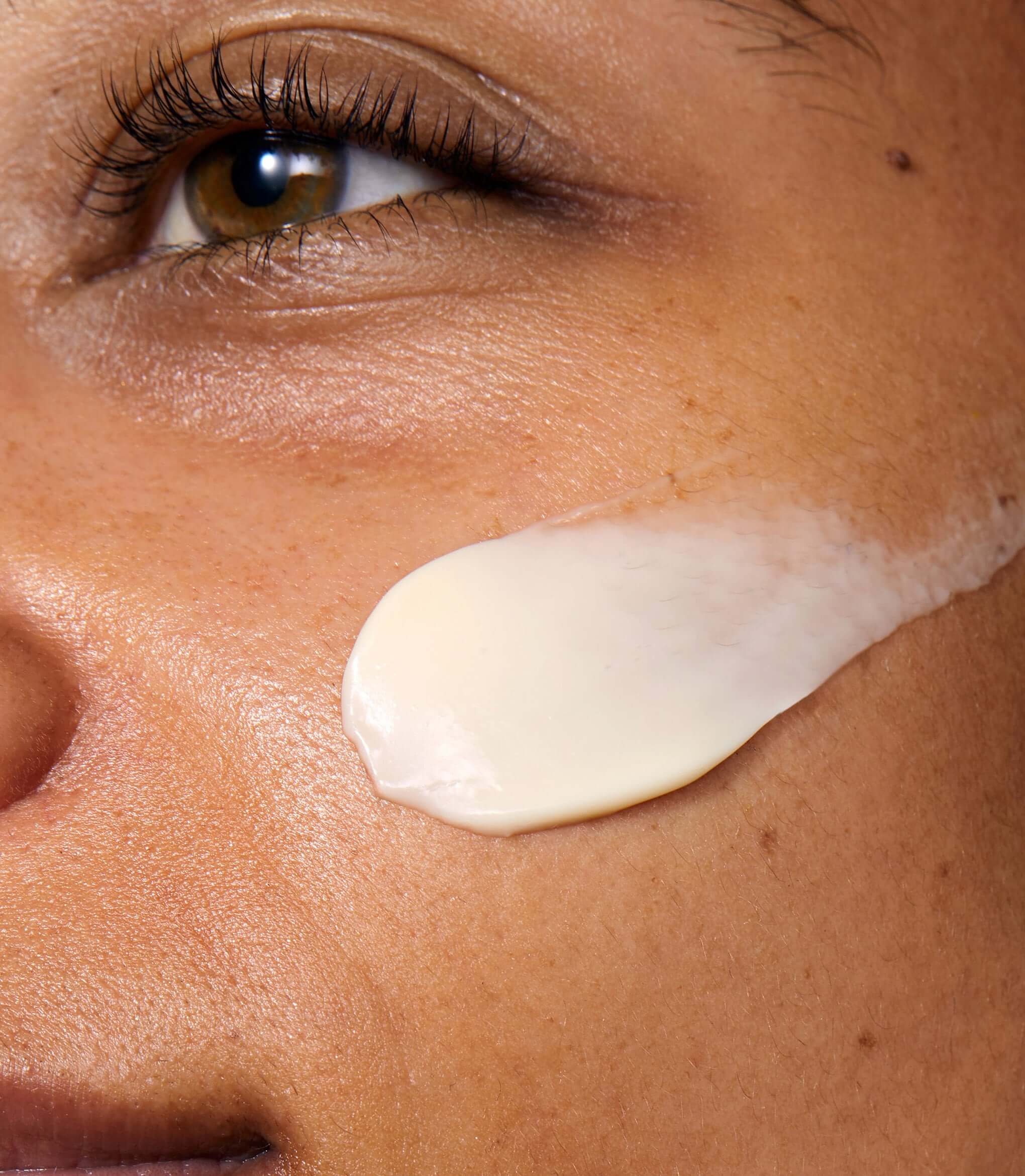 A close up of a model's face with Rejuvenating Night Cream applied to her cheek