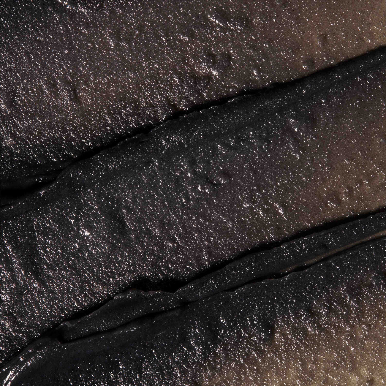 Thick texture of Thermal Cleansing Balm. Formulated with Hungarian Moor Mud the product has deep grey colour.