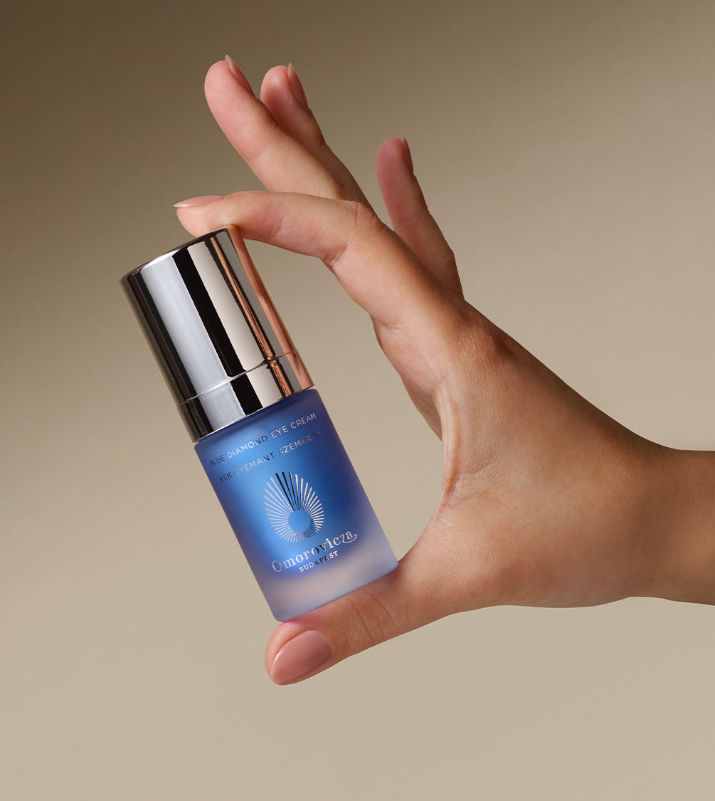 A hand is holding Blue Diamond Eye Cream.