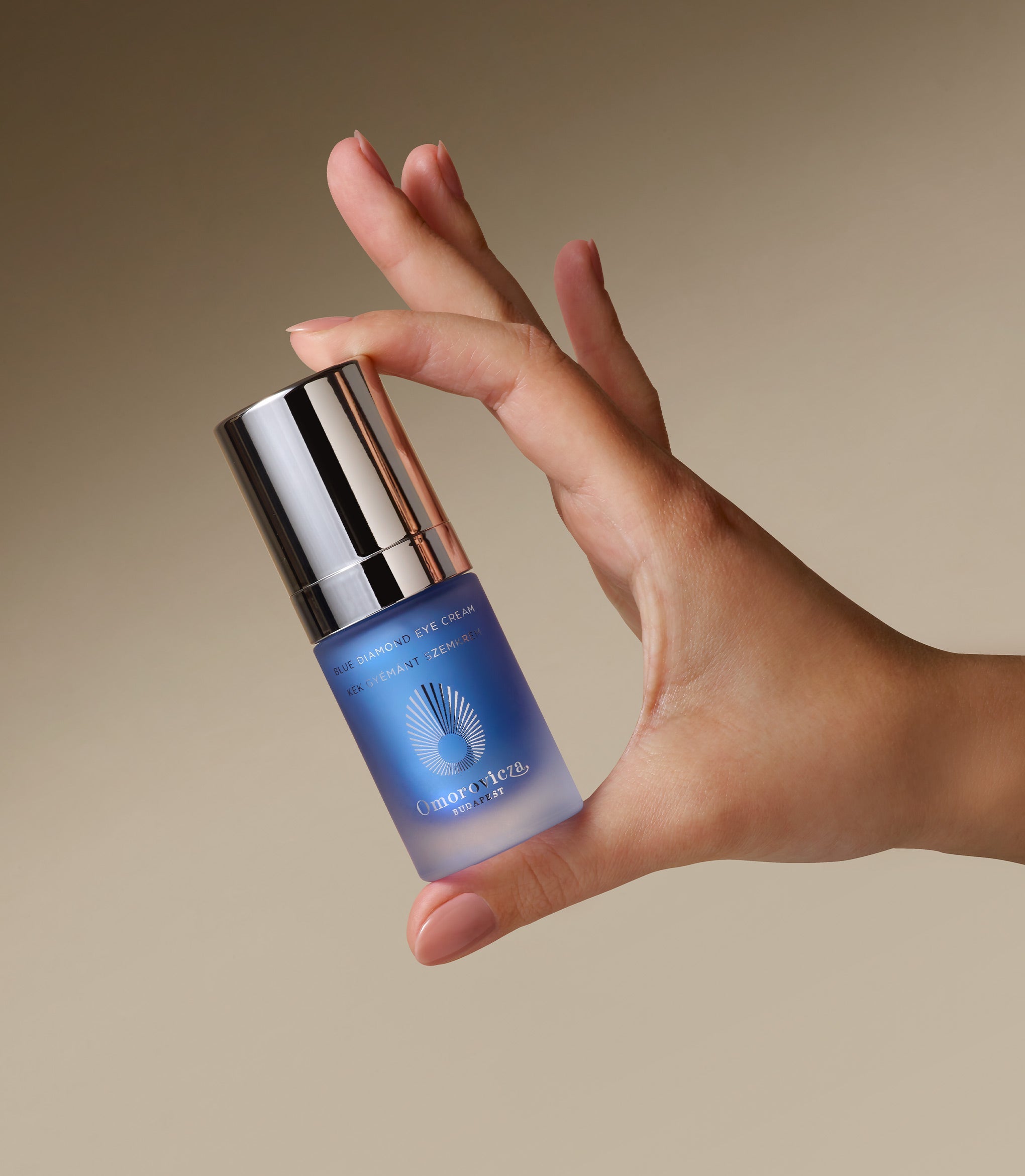 A hand is holding Blue Diamond Eye Cream.