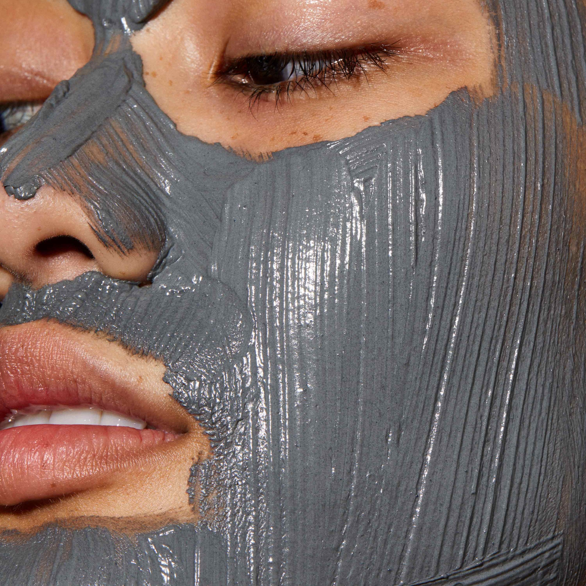 A close up of models face with Ultramoor Mud Mask applied to her face.