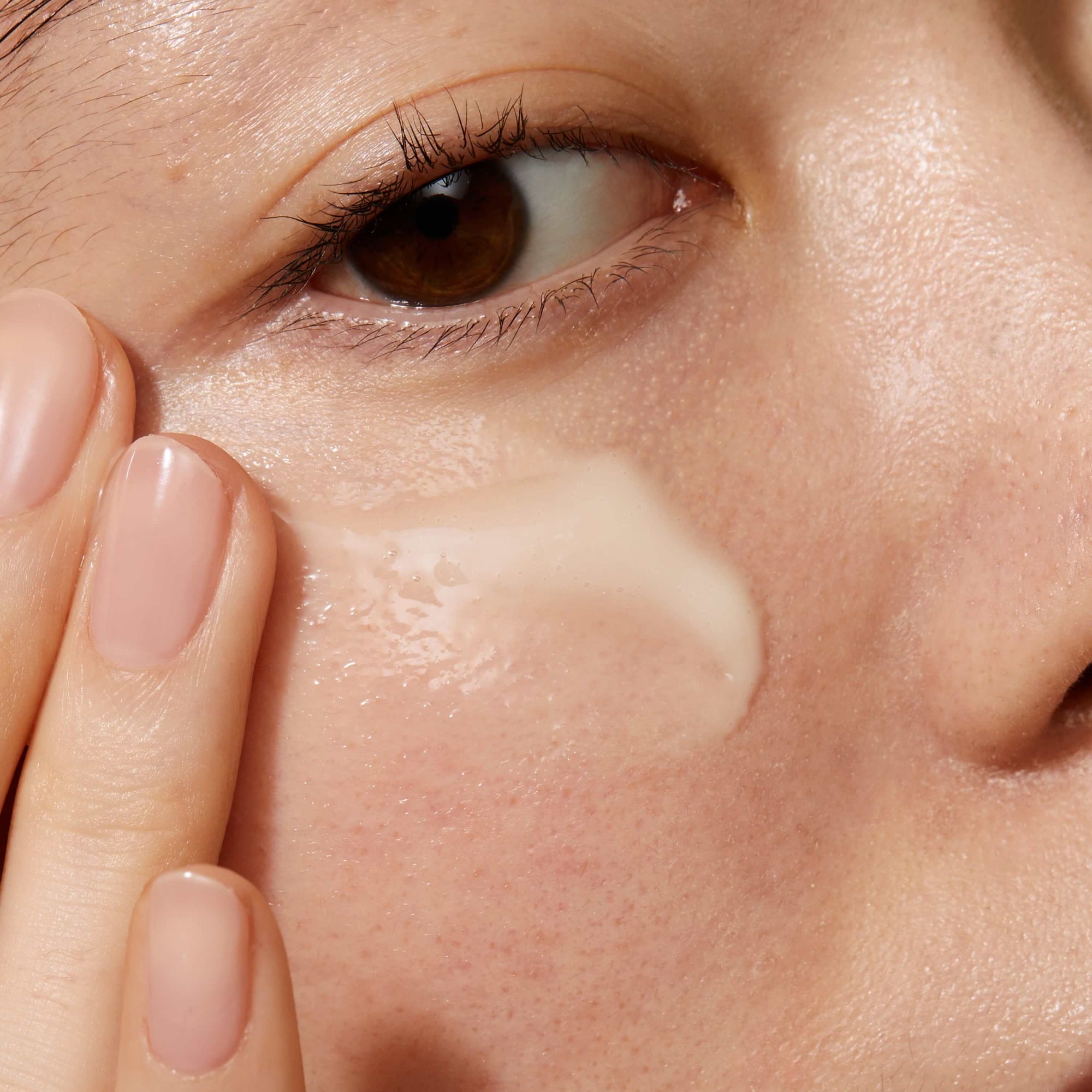 A close up of model's face applying Daily Vitamin C